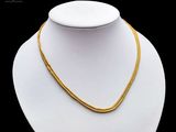a close up of a gold necklace on a mannequin mannequin