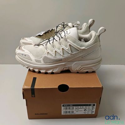 une paire de baskets blanches posée sur une boîte