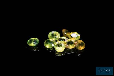 a close up of a bunch of green gems on a black surface