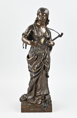 an antique bronze statue of a woman playing a guitar