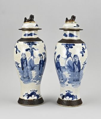 une paire de vases bleus et blancs décorés de personnages