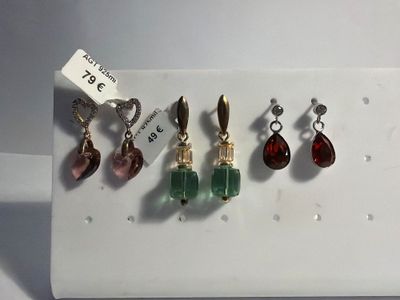 three pairs of earrings are displayed on a white tray