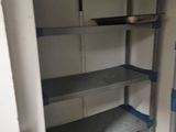 a pantry with shelves that have blue tape on them