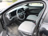 the interior of a car with the door open and the driver ' s seat down