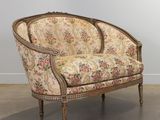 an old chair with a floral upholstered back and wooden legs