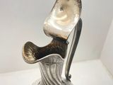 an image of a silver vase on a glass plate