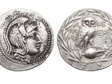 a close up of a coin with an owl on it