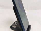 a close up of a cell phone on a stand on a white surface