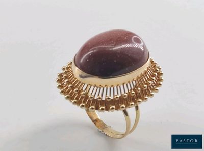 l'image d'une bague en or contenant une pierre rouge