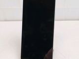 the back of a black cell phone sitting on top of a white table