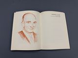 un livre ouvert sur lequel figure le dessin d'un homme en costume-cravate