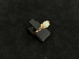 black and gold ring with a pearl on a black surface