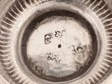 a close up of a silver plate with a clock on it