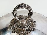 a silver plate with a handle on it on a table