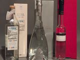 trois bouteilles d'alcool et une boîte de vin posées sur une table