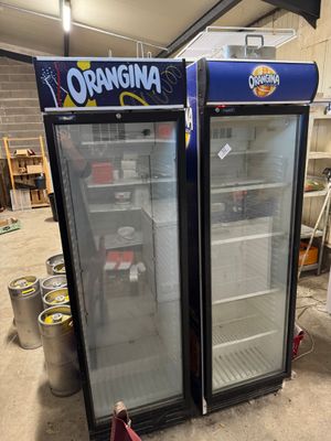 two refrigerators that are next to each other in a room