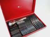 a red box with silverware in it on a white surface