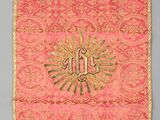a close up of a wall hanging with a cross on it