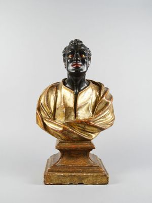 buste en bronze représentant un homme vêtu d'une chemise dorée, posé sur un socle en bois