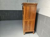 a tall wooden cabinet in the corner of a room