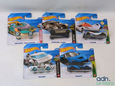 quatre petites voitures Hot Wheels posées sur la table