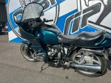 a blue motorcycle parked in front of a blue and white wall
