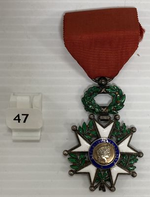 une photo d'une médaille accompagnée d'un ruban rouge posée sur une table