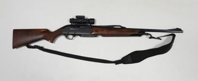 le fusil est posé sur une surface blanche, entouré d'une sangle noire