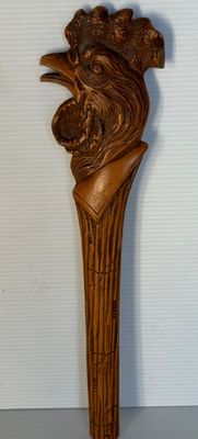 une photo représentant une sculpture en bois représentant une tête de lion fixée sur un bâton