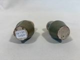 pair of green ceramic salt and pepper shakers on a white background