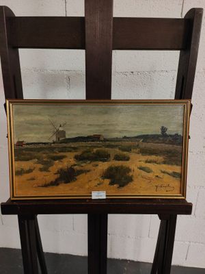 une peinture à l'huile représentant un moulin à vent dans un champ, posée sur une chaise en bois