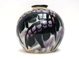 un vase noir et blanc posé sur une surface blanche