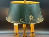 a lamp that is sitting on a table with a green shade