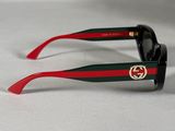 pair of black sunglasses with red and green stripes on a white surface