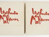 two books with red writing on them sitting next to each other