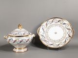 Deux assiettes en porcelaine et une soucoupe sont posées sur une table