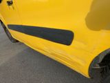 the side of a yellow car with a black stripe painted on it