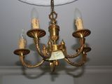 a gold chandelier with five lights hanging from the ceiling