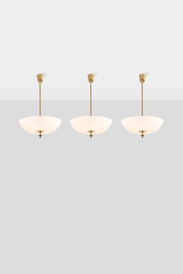 the three light chandelier in brass with white glass shades