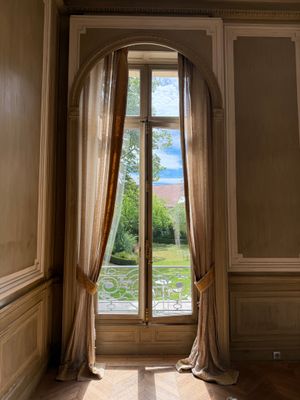 une grande fenêtre dans une pièce donnant sur un champ