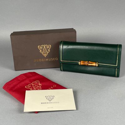 portefeuille en cuir vert avec une poignée en bambou dorée et une pochette en velours rouge