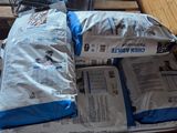 une pile de sacs de courses posés sur une palette à côté d'un caddie