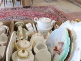 two boxes full of tea cups and saucers on a table