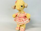 une petite peluche vêtue d'une robe et de chaussures roses