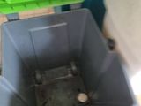 a plastic container with a green lid on a wooden floor