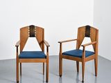 deux chaises en bois avec des coussins rembourrés bleus dans une pièce blanche