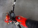 a red motorcycle parked in a garage with a mirror