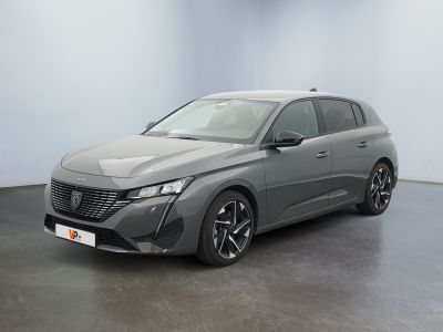 La voiture grise est garée dans une pièce aux murs blancs.