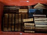 de nombreux livres anciens dans une boîte rouge posée sur la table