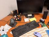 un bureau sur lequel se trouvent un ordinateur, un clavier, une souris et d'autres objets